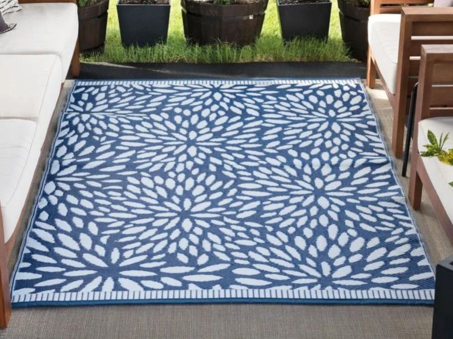 A blue and white Winston Porter Trentin Floral Rug