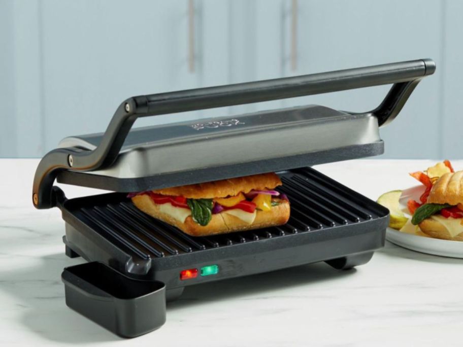 A Wolfgang Puck 1000-Watt Panini Grill with a sandwich grilling