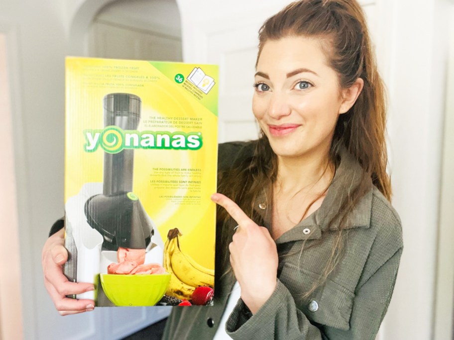 woman holding up and pointing to a yellow Yonanas frozen treat maker box