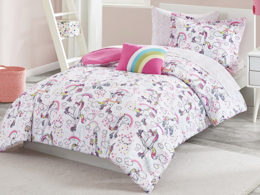 roller skating unicorn print comforter on bed with rainbow throw pillow