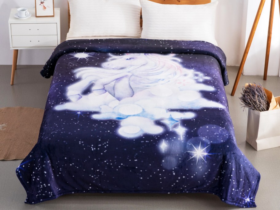 dark purple unicorn print blanket spread across bed