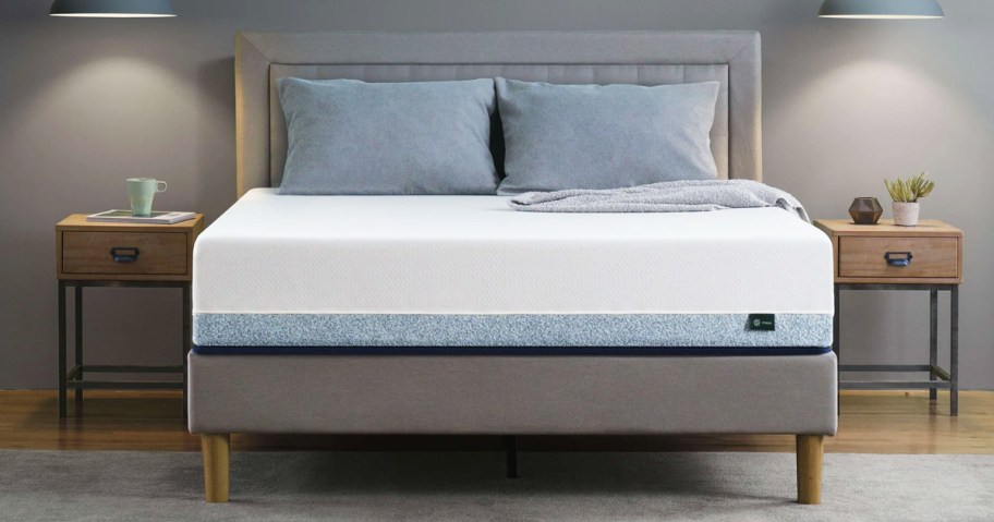 memory foam mattress with pillows on top of a grey bed frame with matching headboard