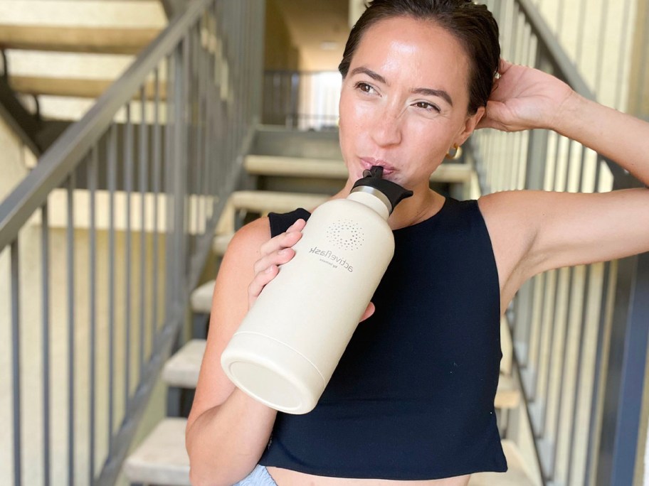 woman drinking from beige activeflask water bottle 
