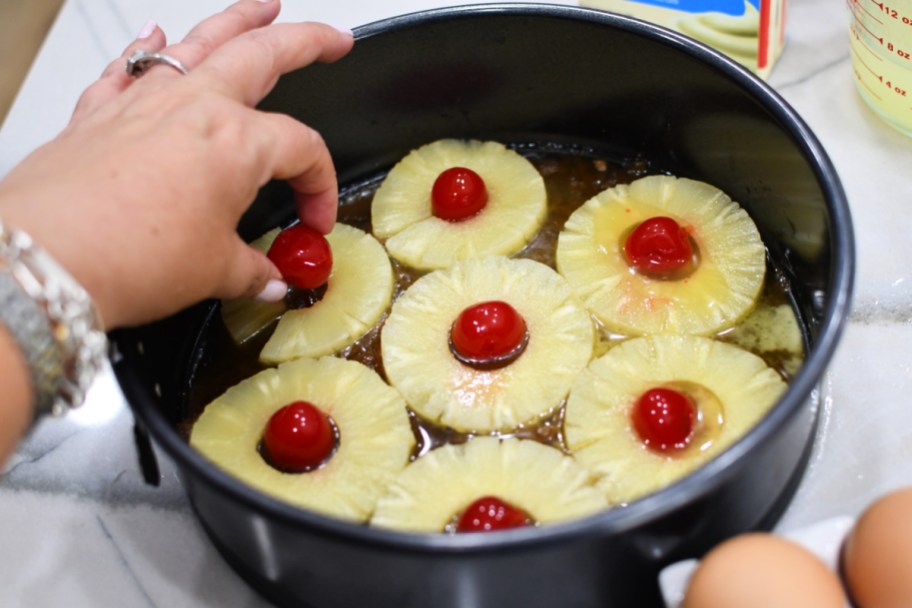 adding cherries to the middle of pineapple