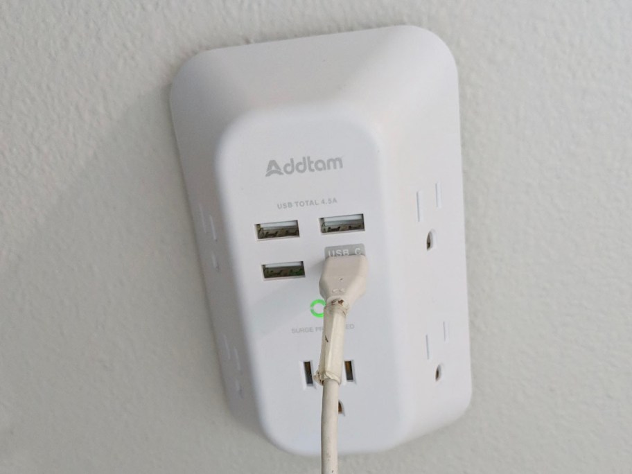 white outlet extender on wall with one cord plugged in 