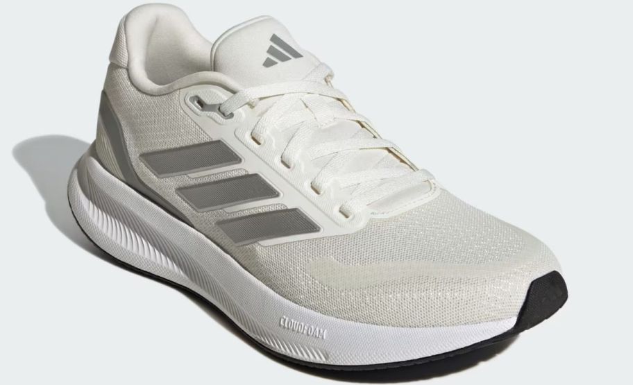 a cream and silver adidas wommens running shoe