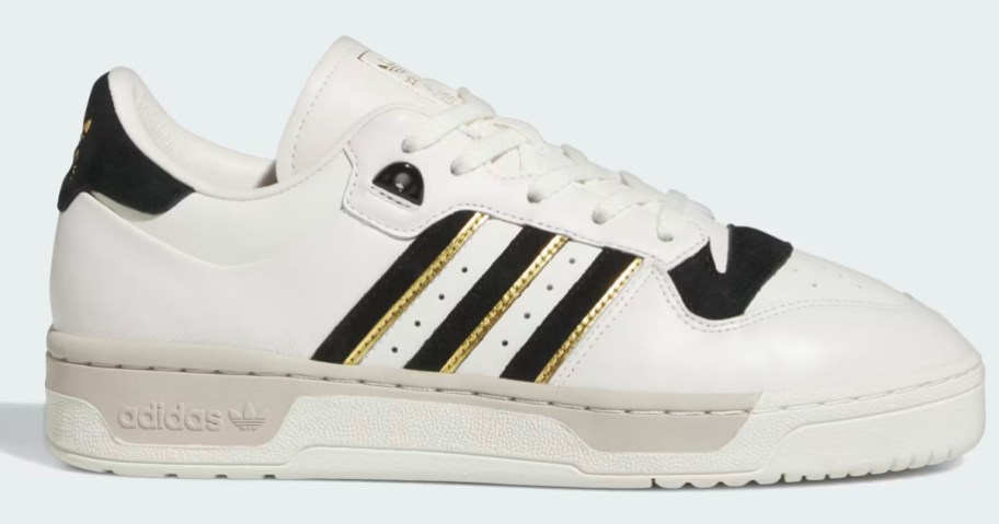 adidas white and black and gold striped shoes stock image