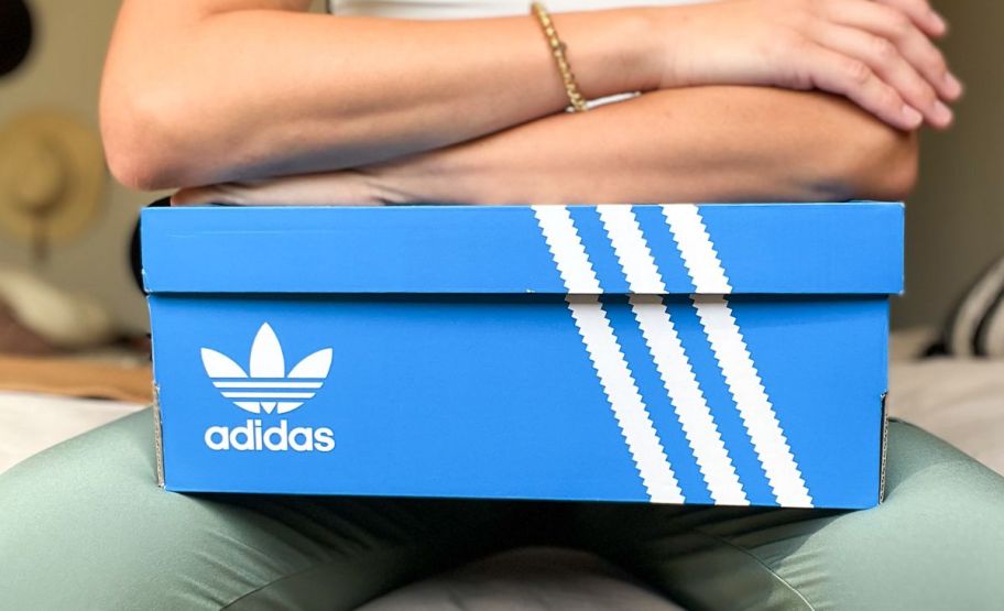 an adidas shoe box on a womans lap