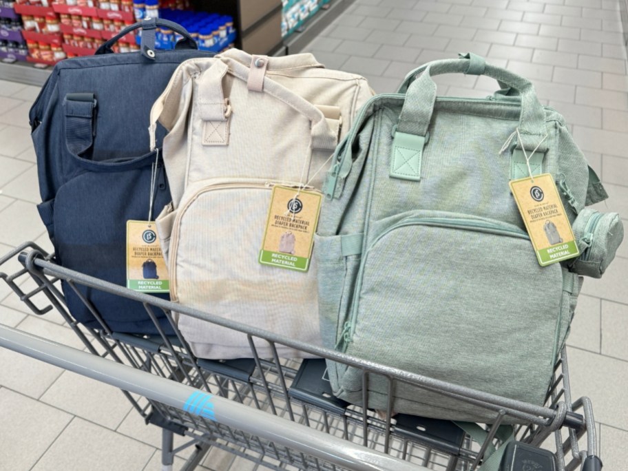blue, tan and light green diaper backpacks in a shopping cart