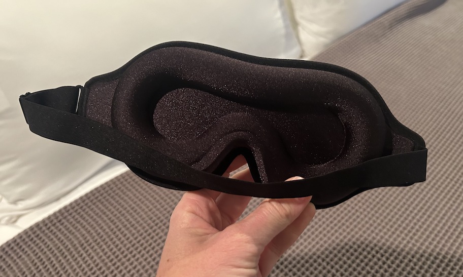 hand holding a black foam sleep mask