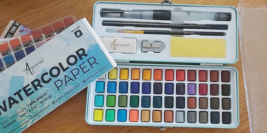 watercolor paint set with brushes on table
