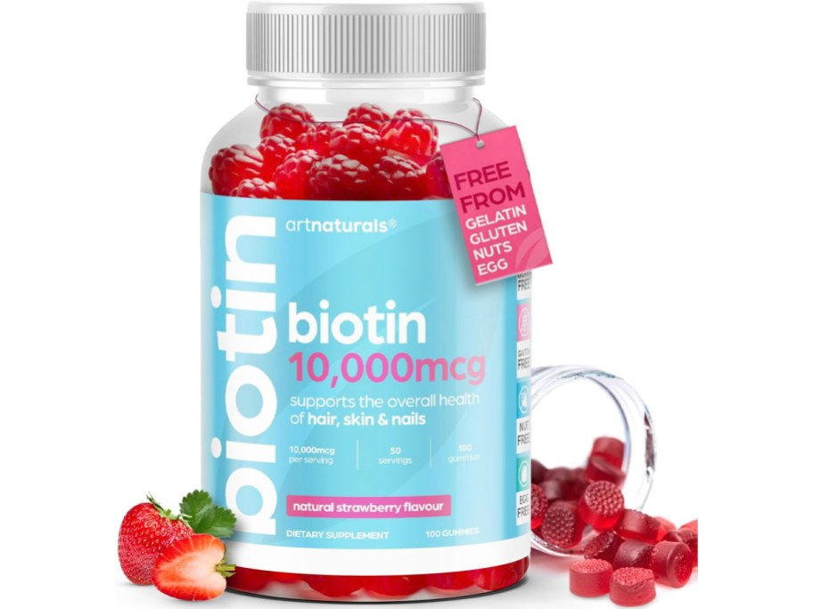 artnaturals biotin gummies bottle with strawberries and gummies laying next to it