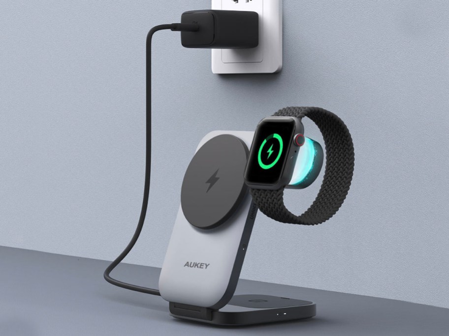 gray aukey power statoin with watch on it plugged into wall