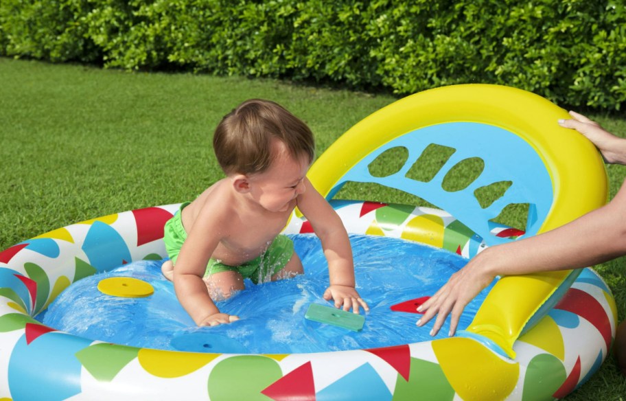 baby playing in kiddie pool with shapes