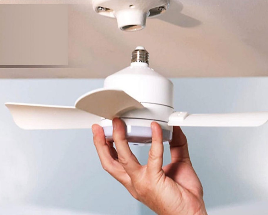 hand screwing fan into light socket