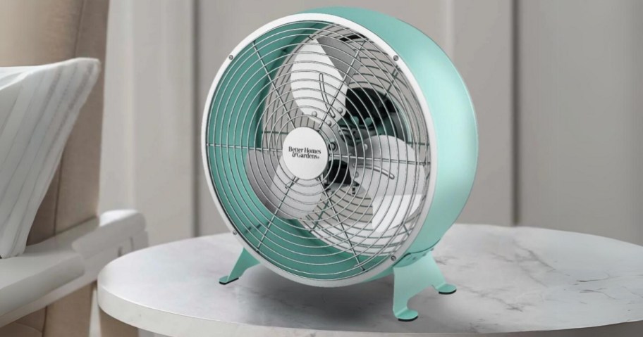 round drum retro style fan in teal blue on a side table