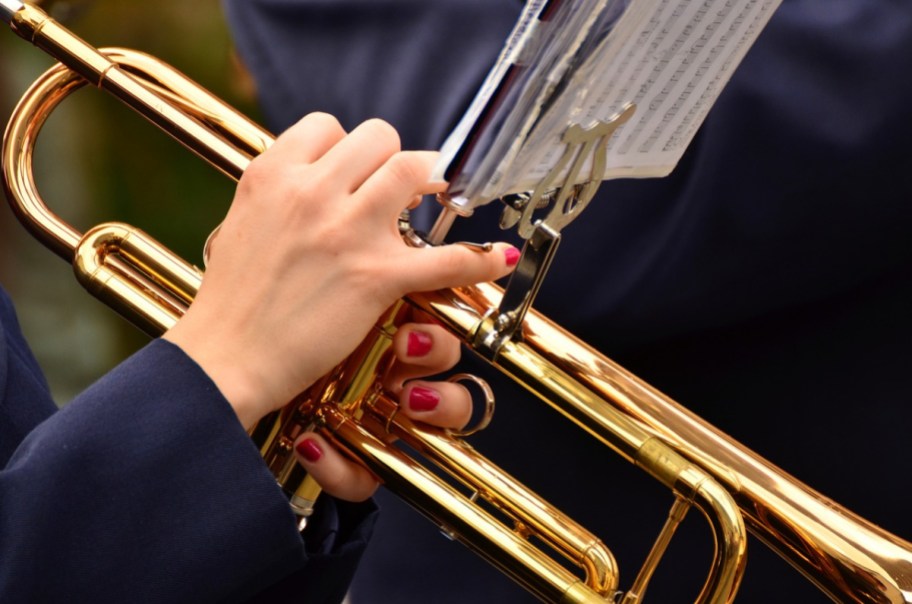 a musician playing in the brass section of an orchestra or marching band thanks to college scholarships for high school seniors