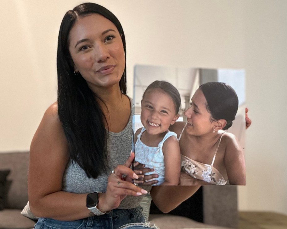 woman holding up canvas of herself and daughter