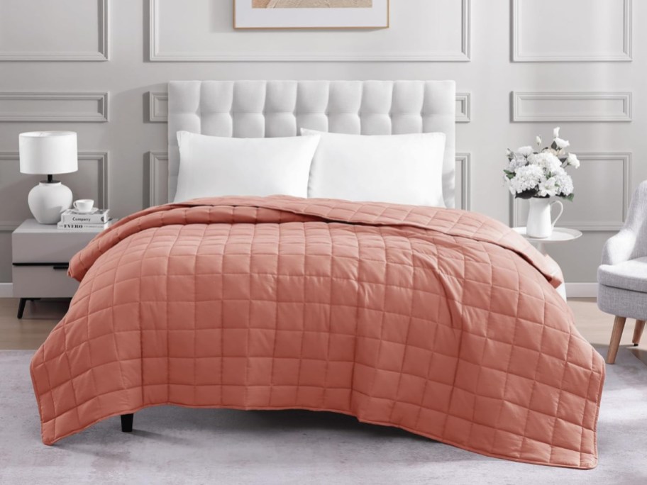 rose colored quilted blanket on bed