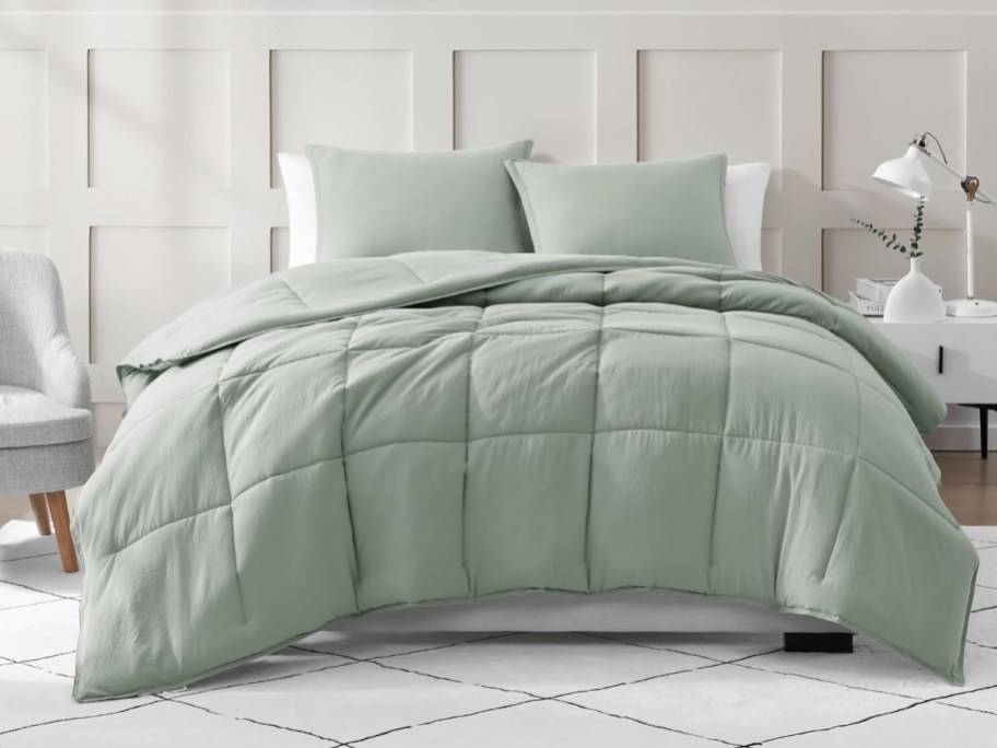sage green duvet and two pillows on bed