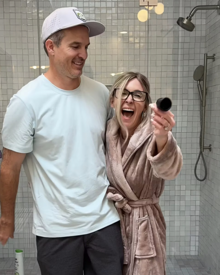 woman standing with man in bathroom holding a menstrual cup