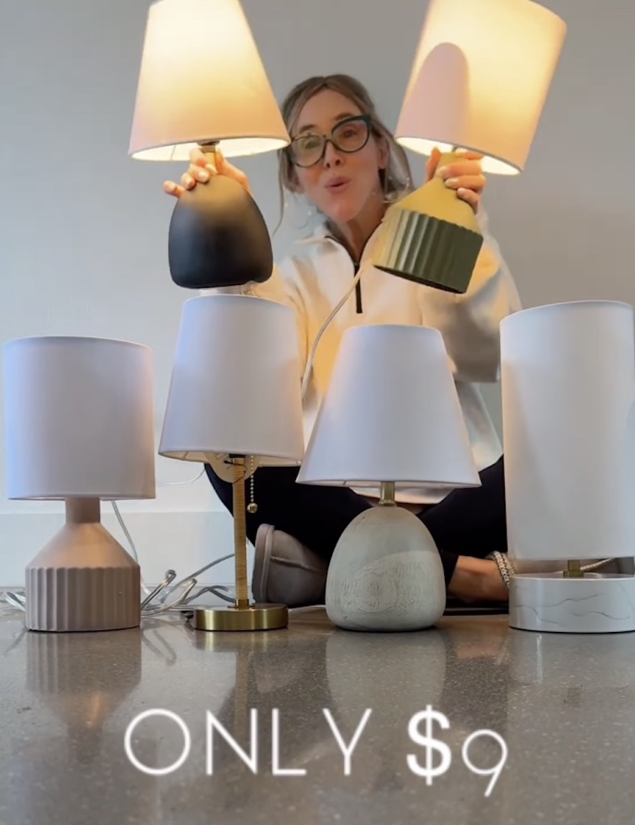 woman holding mini lamps in hands with other lamps on table