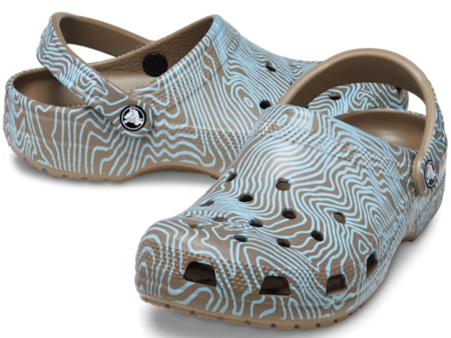 pair of adult's Crocs classic clogs with brown and blue topographic design