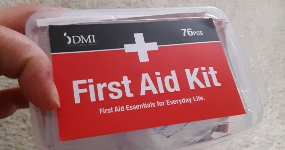 holding a small first aid kit