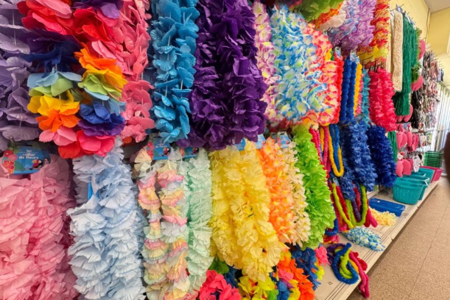 assorted leis hanging on a pegboard in a store