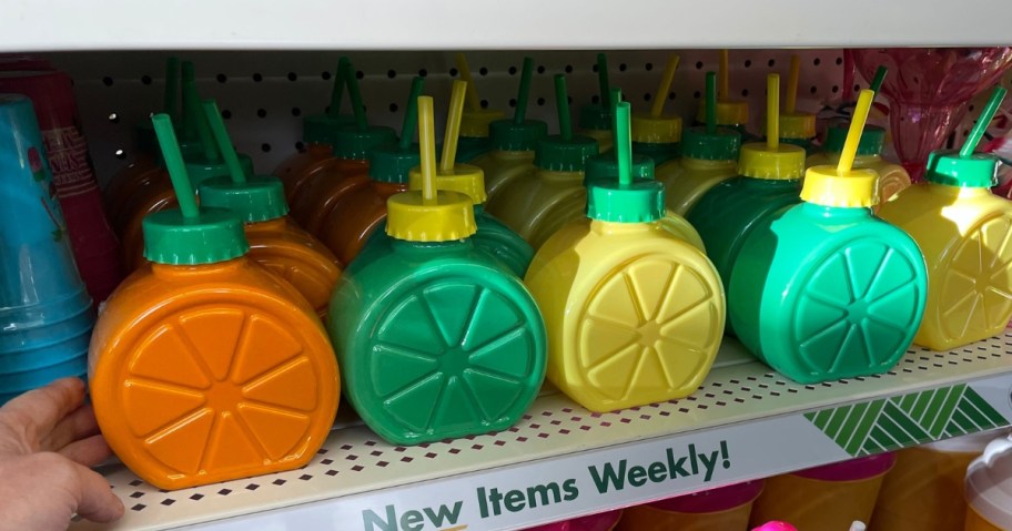 fruit slice shaped water bottles with straws on a shelf