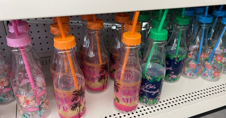 plastic bottles with straws with various summer and luau style designs on a shelf