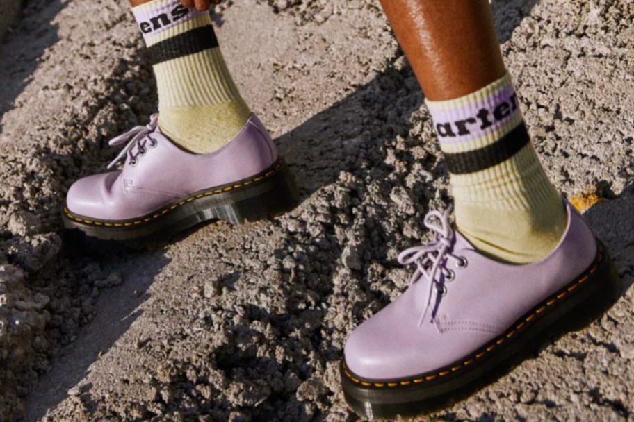 feet on rocks wearing purple dr martens