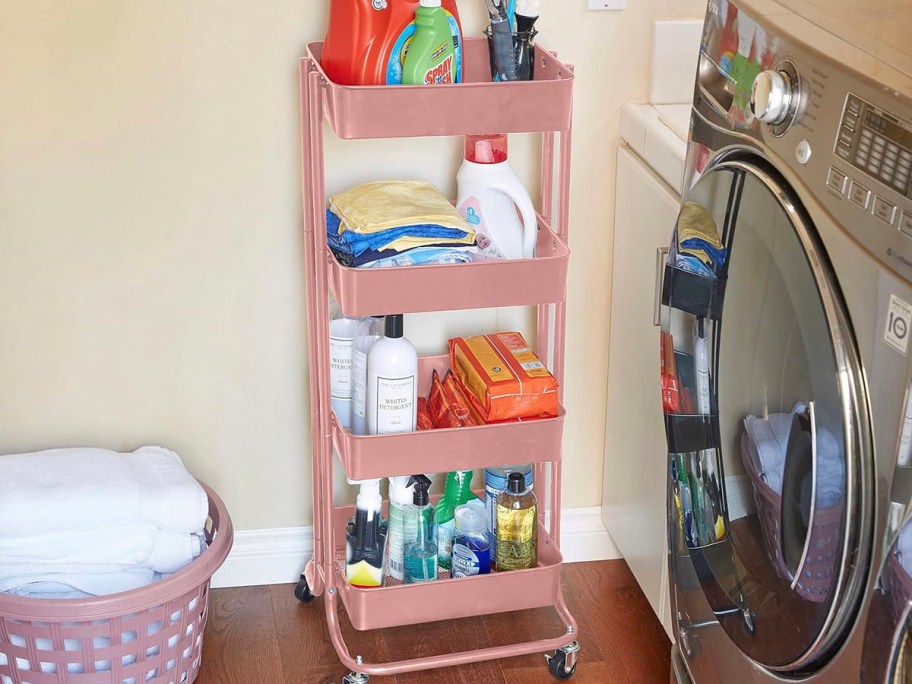pink metal storage cart full of laundry products next to washing machine