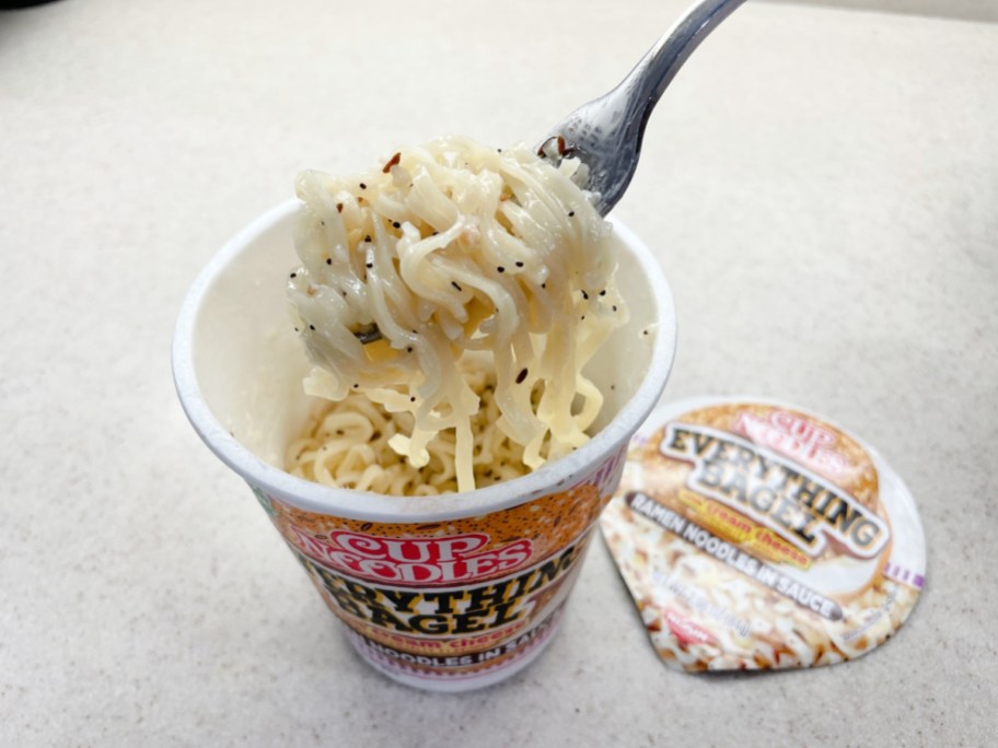 fork lifting out everything bagel cup noodles from the cup