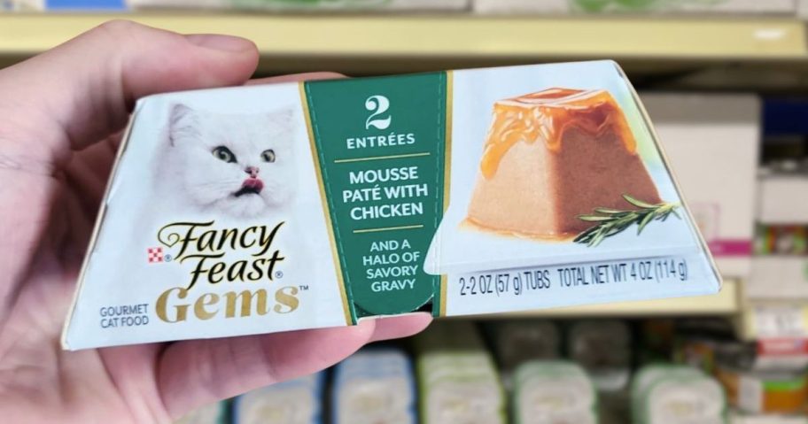 hand holding up cat treat gems in store aisle