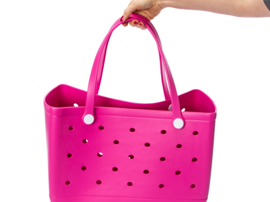 woman holding up a pink five below beach tote