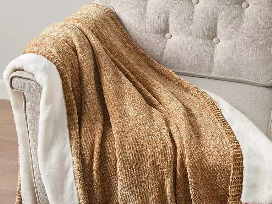 gold reversible blanket laidout on the couch