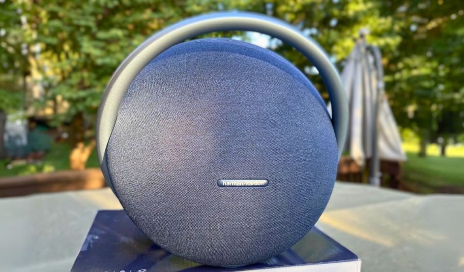 a harman kardon onyx 7 speaker, in blue, outside on a patio