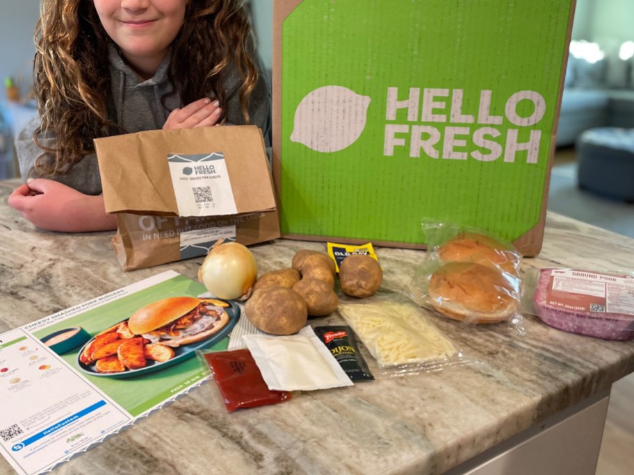 hello fresh box with kid and ingredients on the table