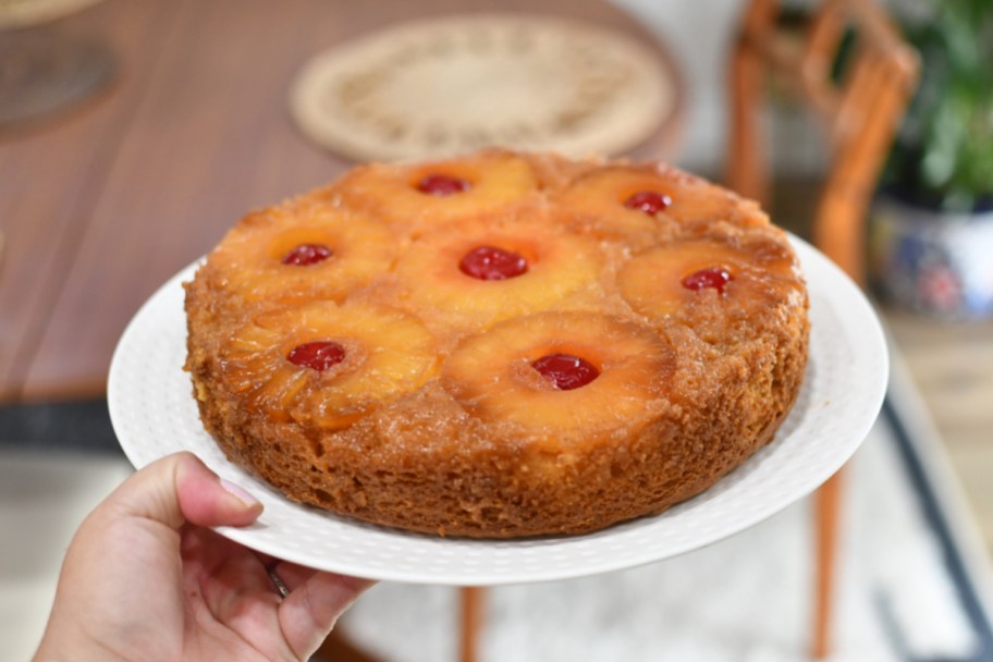 holding a plate with pineapple upside down cake