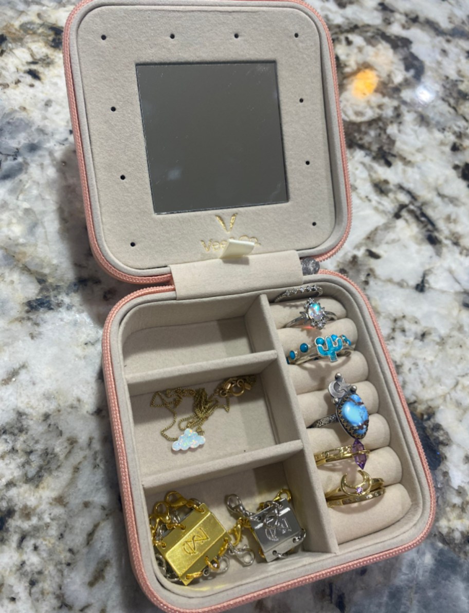 jewelry box organizer on countertop with various rings and earrings inside