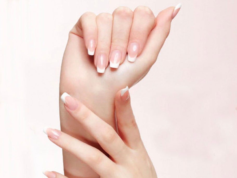 hands wearing white french manicure nails