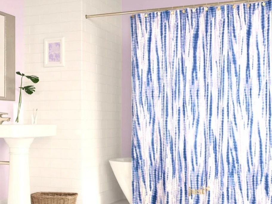white and blue justice shower curtain hanging in bathroom