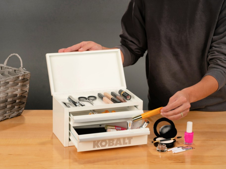 Woman putting makeup in a white Kobalt mini tool box