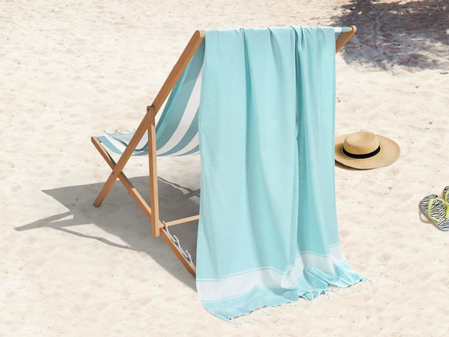 blue lane linen beach towel draped over a beach chair at the beach
