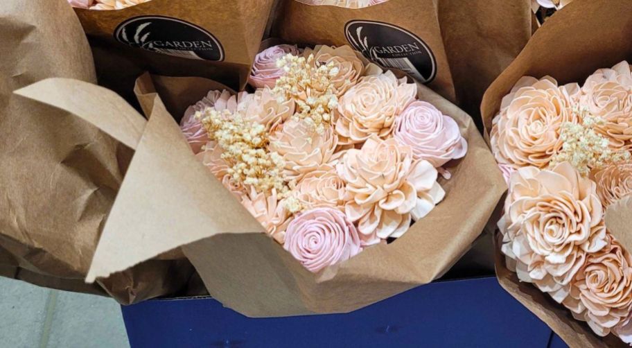 a store display of pink paper flower bouquets with a close up of one bouquet