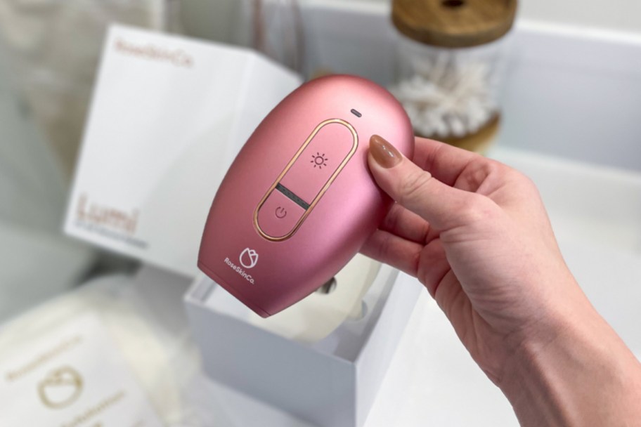 hand holding pink lumi hair removal device