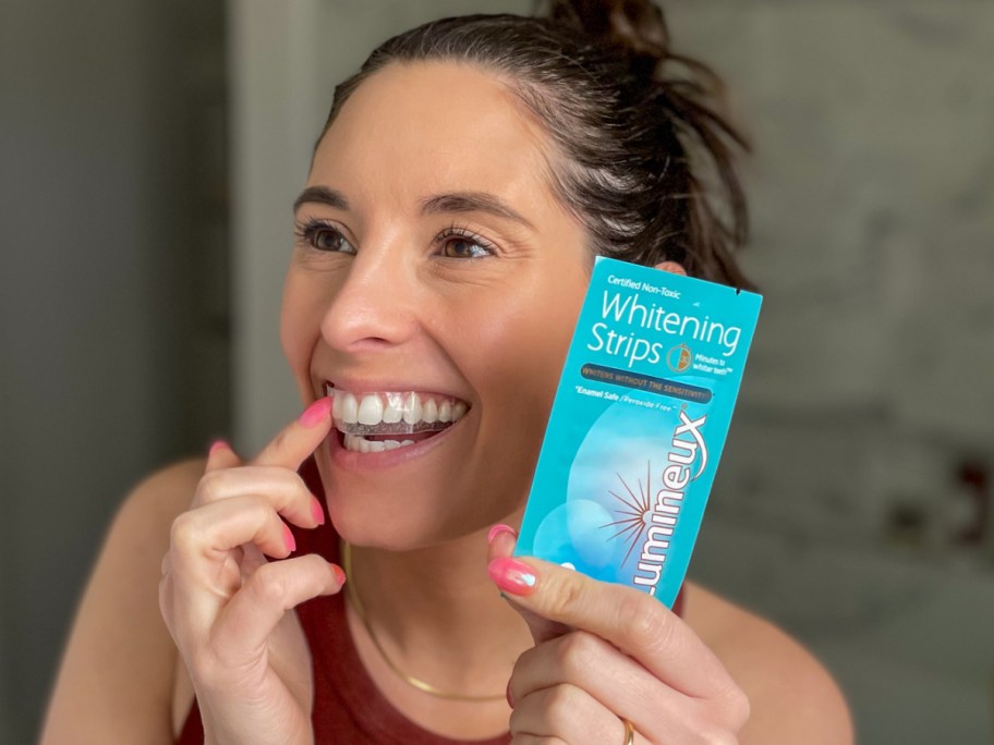 woman applying whitening strips