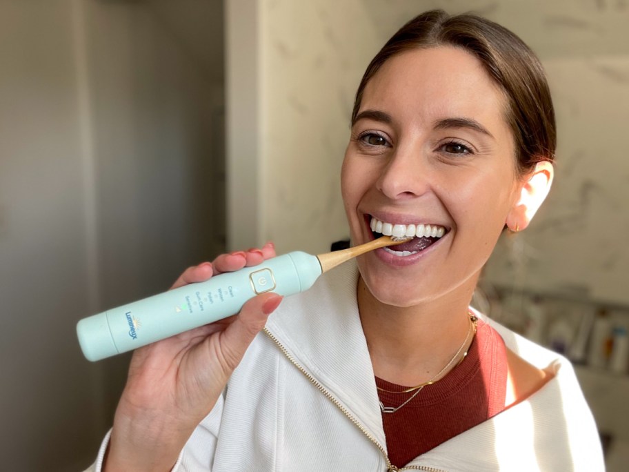 woman using electric toothbrush