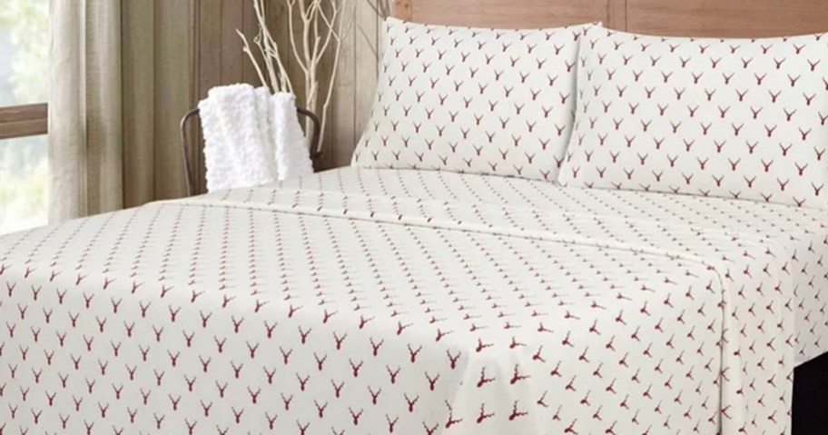 white and red sheet set with stags on bed